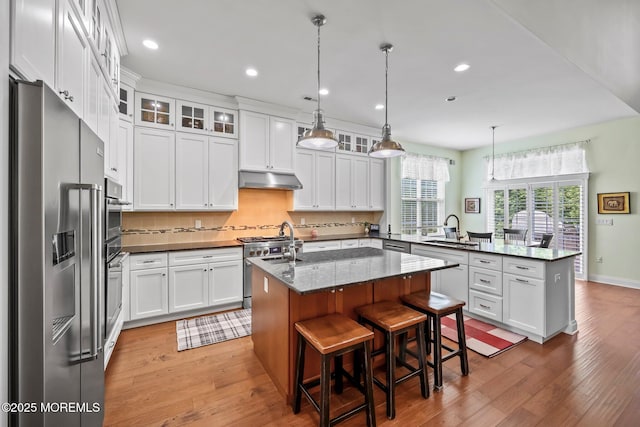 86 Legacy Ct, Freehold, NJ 07728 - kitchen featuring high end appliances, a peninsula, light wood finished floors, a center island with sink, and recessed lighting