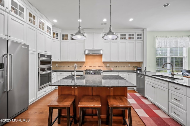 86 Legacy Ct, Freehold, NJ 07728 - kitchen with stainless steel appliances, under cabinet range hood, wood finished floors, an island with sink, and recessed lighting