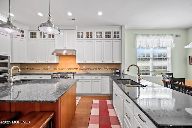 86 Legacy Ct, Freehold, NJ 07728 - kitchen featuring under cabinet range hood, recessed lighting, a peninsula, white cabinetry, and glass insert cabinets