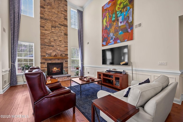 86 Legacy Ct, Freehold, NJ 07728 - living room featuring a towering ceiling, wood finished floors, a fireplace, a wainscoted wall, and a decorative wall