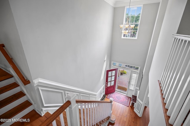 86 Legacy Ct, Freehold, NJ 07728 - foyer entrance featuring a chandelier, stairway, crown molding, wood finished floors, and wainscoting