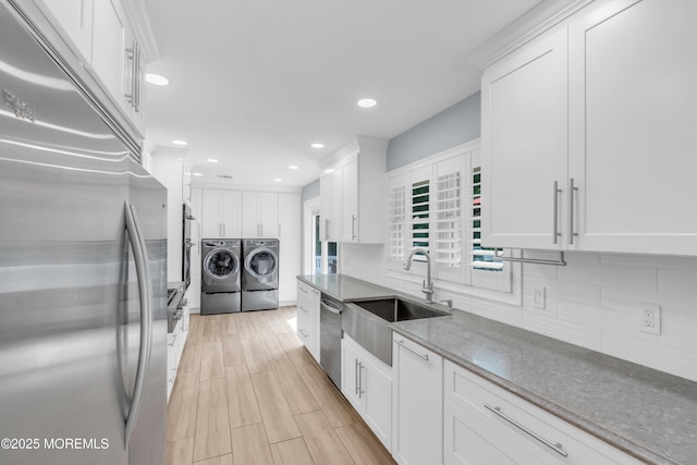 18 Pinewood Dr, Brick, NJ 08724 - kitchen with stainless steel appliances, washer and clothes dryer, white cabinets, backsplash, and dark stone counters