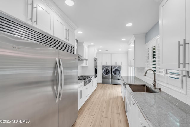 18 Pinewood Dr, Brick, NJ 08724 - kitchen featuring stainless steel appliances, washing machine and clothes dryer, white cabinetry, light stone counters, and recessed lighting
