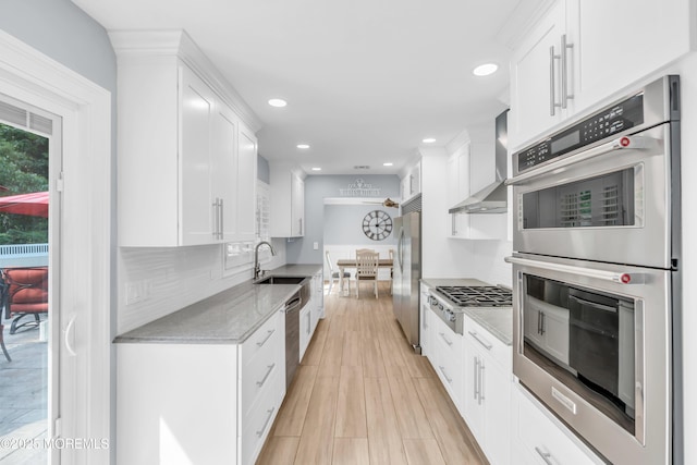 18 Pinewood Dr, Brick, NJ 08724 - kitchen with stainless steel appliances, wall chimney exhaust hood, white cabinetry, recessed lighting, and light stone counters