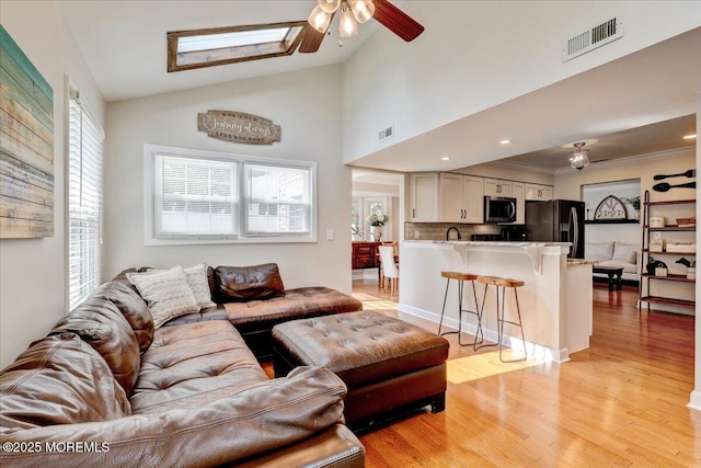 46 Sweet Gum Rd, Howell, NJ 07731 - living area with ceiling fan, light wood finished floors, vaulted ceiling, crown molding, and a skylight