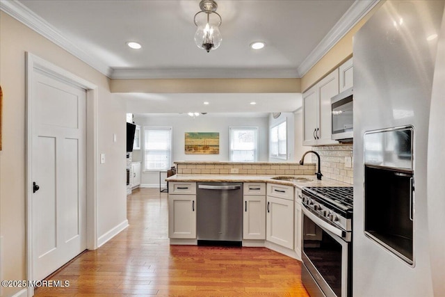 46 Sweet Gum Rd, Howell, NJ 07731 - kitchen featuring stainless steel appliances, a peninsula, ornamental molding, healthy amount of natural light, and backsplash