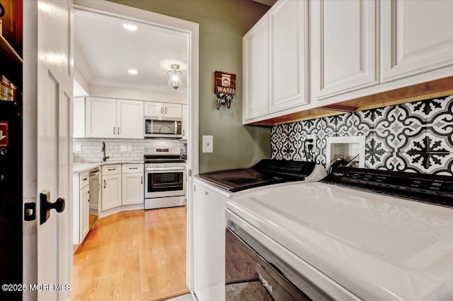 46 Sweet Gum Rd, Howell, NJ 07731 - laundry room with washer and clothes dryer, light wood-style floors, cabinet space, crown molding, and recessed lighting