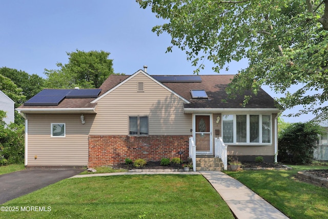 8 Donnelly St, Union Beach, NJ 07735 - view of front of home featuring roof mounted solar panels, a front yard, brick siding, a shingled roof, and entry steps