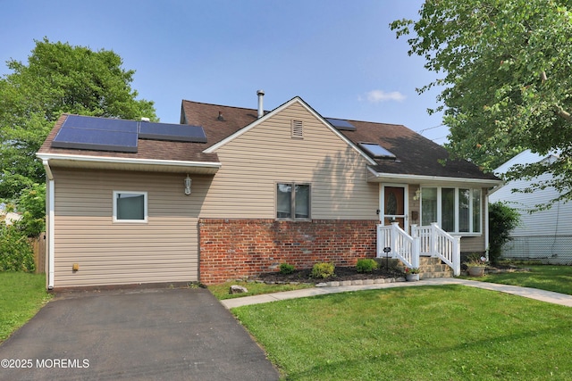 8 Donnelly St, Union Beach, NJ 07735 - view of front of house featuring brick siding, solar panels, a front yard, and a shingled roof