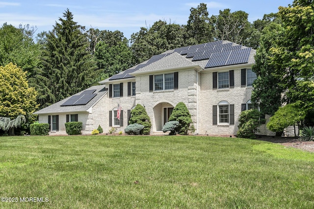 16 Chestnut Dr, Colts Neck, NJ 07722 - view of front of home featuring solar panels, a front lawn, and brick siding