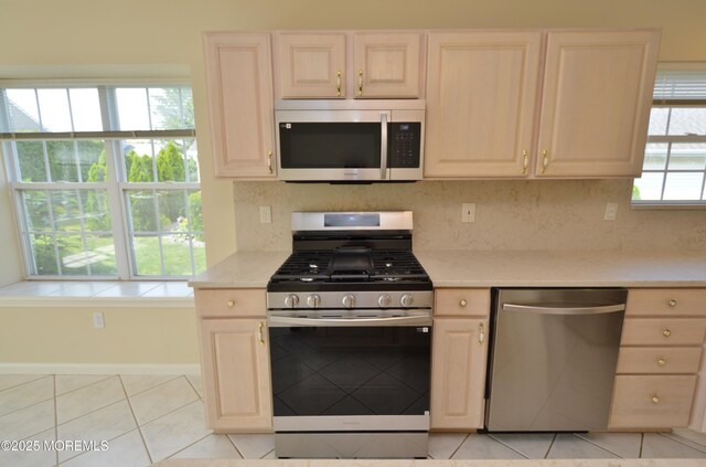 3168 Wood Spring Ln, Toms River, NJ 08755 - kitchen featuring stainless steel appliances, light tile patterned flooring, light brown cabinets, and backsplash