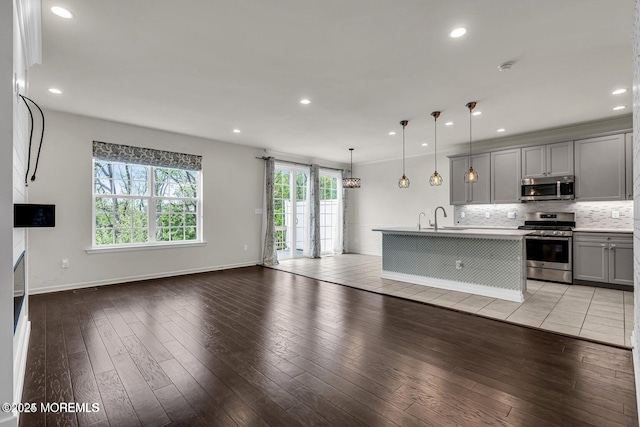 44 Begonia Ln, Monroe, NJ 08831 - kitchen featuring appliances with stainless steel finishes, gray cabinets, open floor plan, decorative backsplash, and light wood finished floors