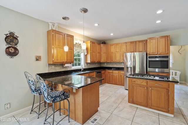301 Cranberry Rd, Farmingdale, NJ 07727 - kitchen with stainless steel appliances, a peninsula, dark stone counters, tasteful backsplash, and decorative light fixtures