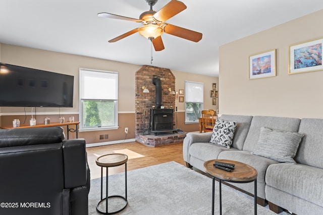387 Barnegat Ln, Brick, NJ 08723 - living area featuring a wood stove, wood finished floors, and a ceiling fan