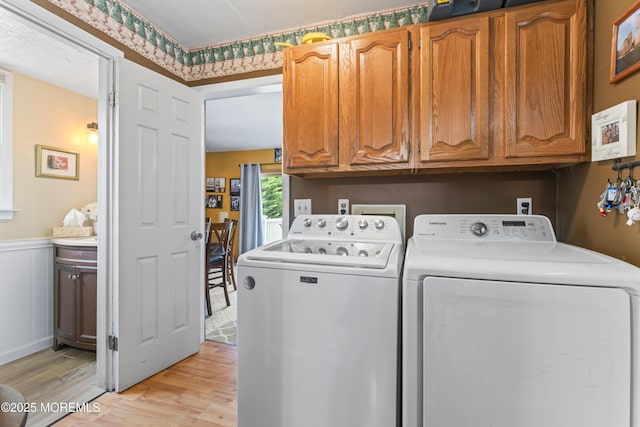 387 Barnegat Ln, Brick, NJ 08723 - laundry area featuring independent washer and dryer, cabinet space, light wood-style flooring, and a wainscoted wall