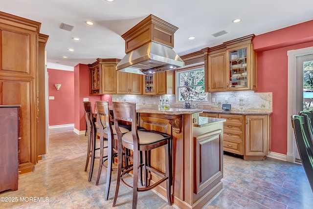 339 Ueland Rd, Red Bank, NJ 07701 - kitchen featuring island range hood, backsplash, recessed lighting, stone finish flooring, and a breakfast bar