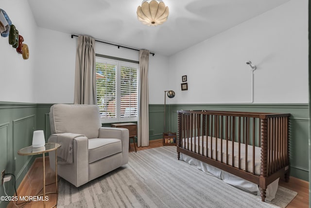 45 Victory Ct, Old Bridge, NJ 08857 - bedroom with a wainscoted wall, wood finished floors, a decorative wall, and a crib