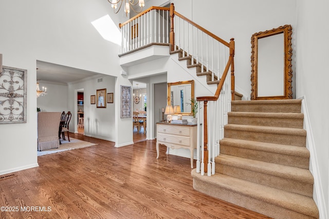3058 Governors Xing, Wall, NJ 07719 - staircase with a chandelier, wood finished floors, a high ceiling, and ornamental molding