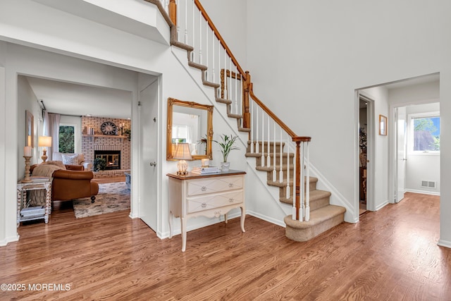 3058 Governors Xing, Wall, NJ 07719 - staircase with wood finished floors, plenty of natural light, a brick fireplace, and a high ceiling