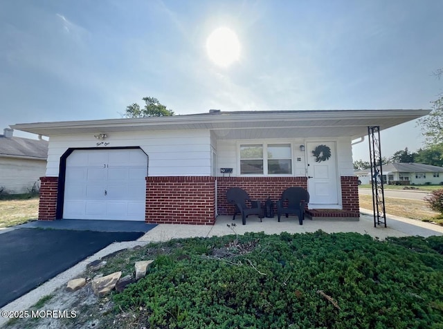 31 Guadeloupe Dr, Toms River, NJ 08757 - view of front facade featuring brick siding, a garage, a porch, and asphalt driveway