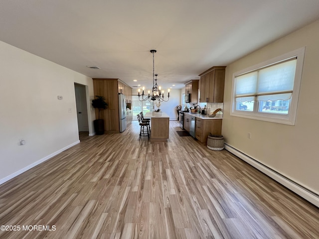 31 Guadeloupe Dr, Toms River, NJ 08757 - kitchen featuring appliances with stainless steel finishes, a chandelier, a baseboard heating unit, light countertops, and light wood-style flooring