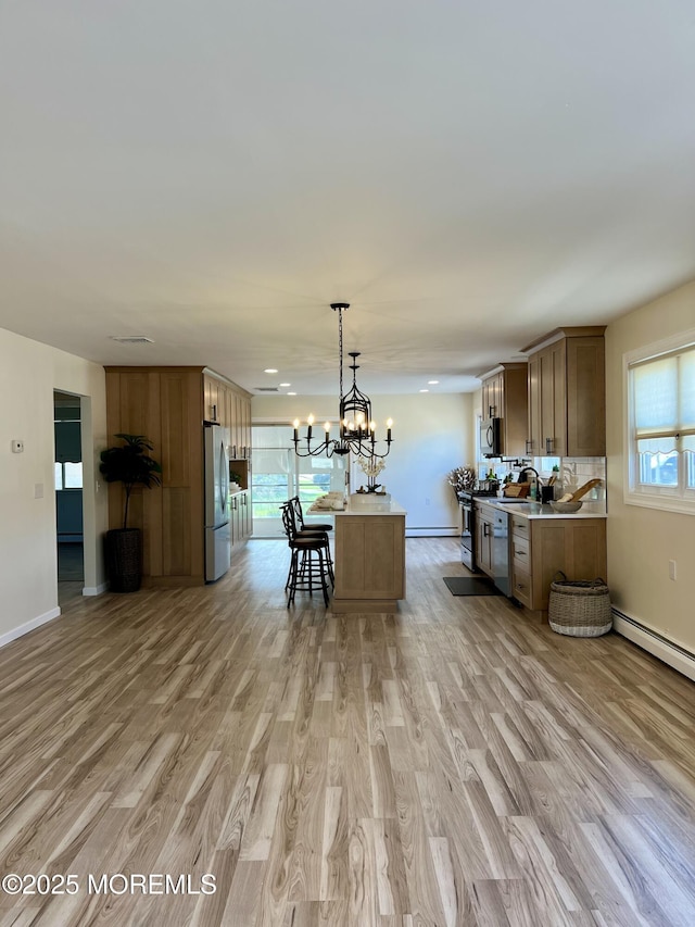 31 Guadeloupe Dr, Toms River, NJ 08757 - kitchen featuring stainless steel appliances, light wood finished floors, a chandelier, light countertops, and a baseboard radiator
