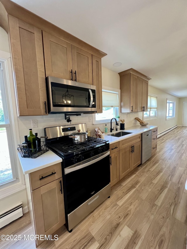 31 Guadeloupe Dr, Toms River, NJ 08757 - kitchen with stainless steel appliances, light wood finished floors, baseboard heating, backsplash, and light countertops