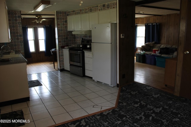 146 Mockingbird Way, Whiting, NJ 08759 - kitchen with freestanding refrigerator, stainless steel electric stove, wooden walls, white cabinets, and ceiling fan