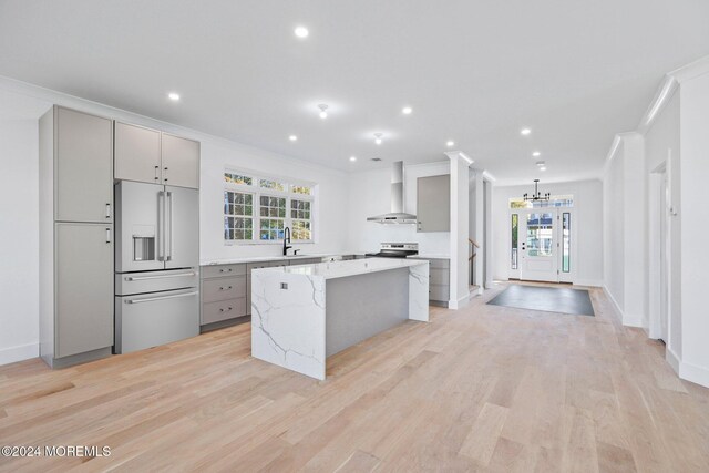 143 Stokes Pl, Long Branch, NJ 07740 - kitchen with high end refrigerator, wall chimney exhaust hood, gray cabinetry, crown molding, and a center island