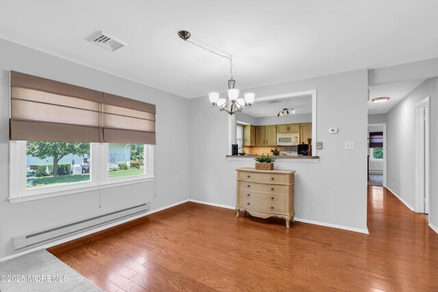 65 Sycamore Rd, Manahawkin, NJ 08050 - dining space featuring a baseboard heating unit, a chandelier, and wood finished floors