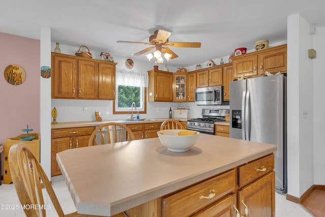 26 Shasta Ln, Toms River, NJ 08753 - kitchen featuring stainless steel appliances, ceiling fan, glass insert cabinets, brown cabinetry, and backsplash