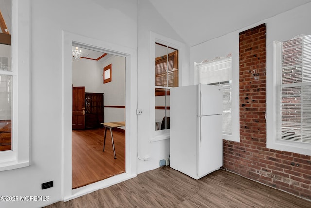 55 E Front St, Keyport, NJ 07735 - hallway with wood finished floors, lofted ceiling, a chandelier, and brick wall