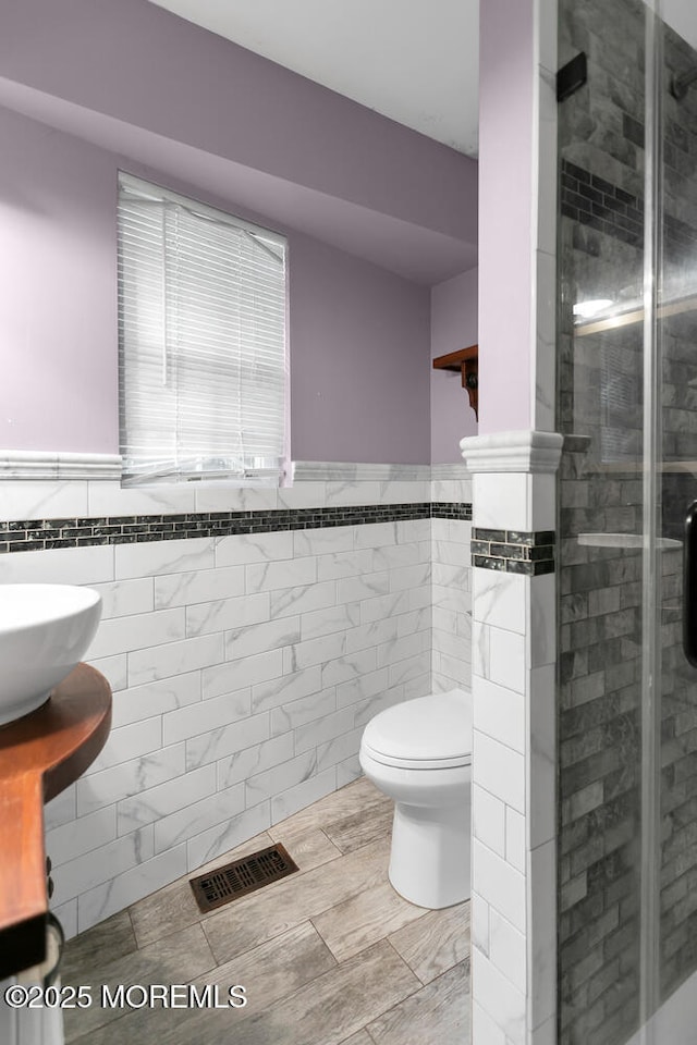 55 E Front St, Keyport, NJ 07735 - bathroom featuring tile walls, a stall shower, and a wainscoted wall