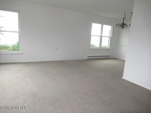 10 Dunstable Rd, Vincentown, NJ 08088 - spare room with a baseboard heating unit, a chandelier, and carpet floors