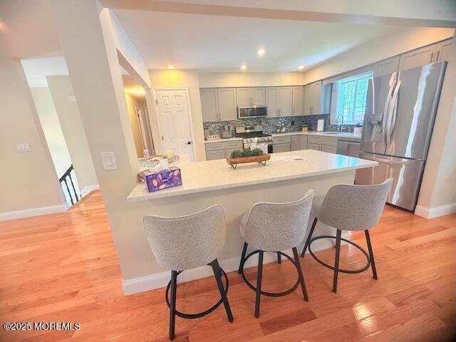 11 Bristlecone Dr, Howell, NJ 07731 - kitchen featuring stainless steel appliances, gray cabinetry, a peninsula, a breakfast bar area, and recessed lighting