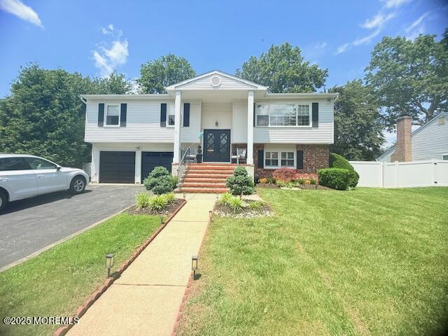11 Bristlecone Dr, Howell, NJ 07731 - bi-level home with asphalt driveway, an attached garage, and brick siding