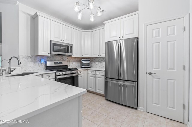 22 Cooper Ave Unit 113, Long Branch, NJ 07740 - kitchen featuring stainless steel appliances, light stone countertops, backsplash, light tile patterned floors, and white cabinets