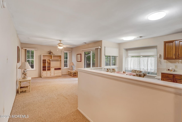 406 Betsy Ross Ln, Little Egg Harbor, NJ 08087 - kitchen with light colored carpet, brown cabinetry, plenty of natural light, and ceiling fan
