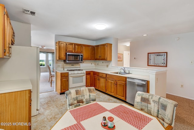 406 Betsy Ross Ln, Little Egg Harbor, NJ 08087 - kitchen featuring stainless steel appliances, light countertops, brown cabinets, a peninsula, and light carpet