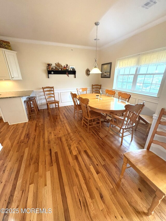 119 Dupont Ave Unit 10, Seaside Heights, NJ 08751 - dining room featuring light wood finished floors, crown molding, wainscoting, and a decorative wall