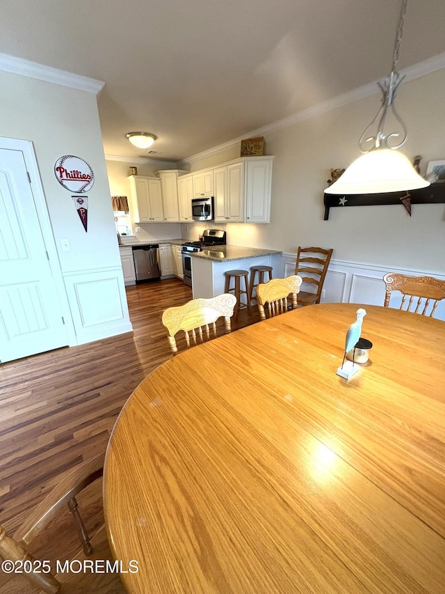 119 Dupont Ave Unit 10, Seaside Heights, NJ 08751 - dining space featuring crown molding, dark wood finished floors, a wainscoted wall, and a decorative wall