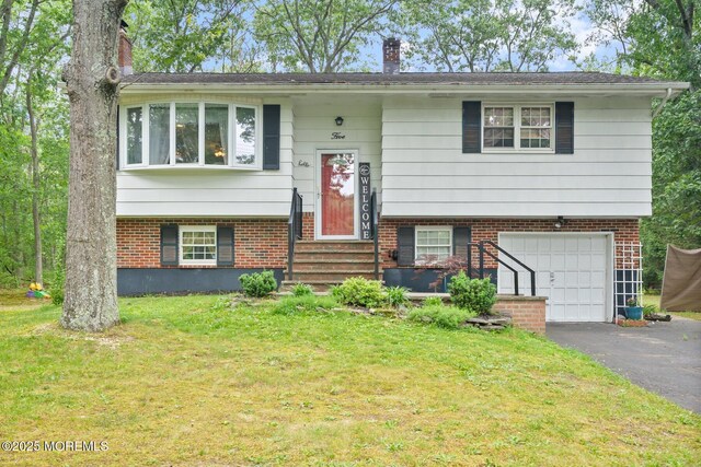 5 Poplar St, Jackson, NJ 08527 - split foyer home with an attached garage, a chimney, asphalt driveway, a front lawn, and brick siding