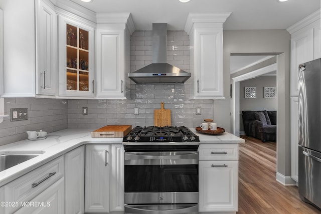 36 Sally St, Howell, NJ 07731 - kitchen with wall chimney exhaust hood, appliances with stainless steel finishes, white cabinets, and wood finished floors