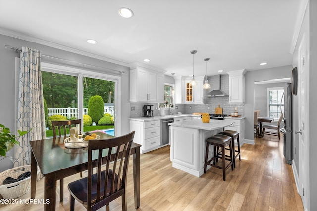 36 Sally St, Howell, NJ 07731 - kitchen with wall chimney exhaust hood, stainless steel appliances, white cabinetry, a kitchen island, and tasteful backsplash