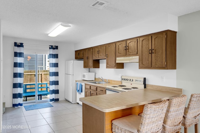 3100 Rte 35 Unit 6, Lavallette, NJ 08735 - kitchen featuring white appliances, under cabinet range hood, light countertops, a textured ceiling, and a peninsula