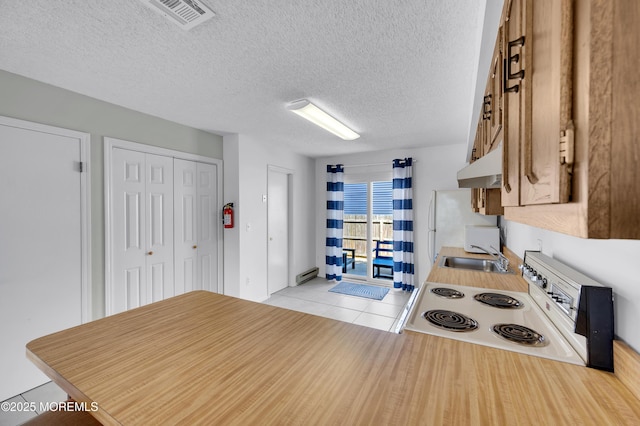 3100 Rte 35 Unit 6, Lavallette, NJ 08735 - kitchen with white electric stove, under cabinet range hood, light tile patterned floors, a baseboard heating unit, and a textured ceiling