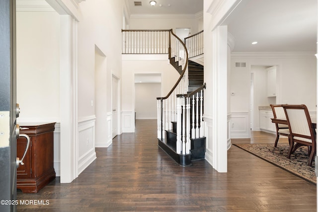 11 Potomac Ct, Freehold, NJ 07728 - foyer with dark wood-type flooring, stairway, ornamental molding, a decorative wall, and a wainscoted wall