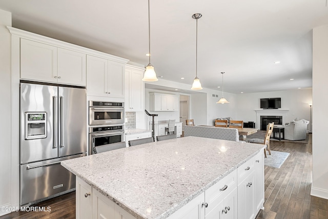 11 Potomac Ct, Freehold, NJ 07728 - kitchen with stainless steel appliances, a glass covered fireplace, recessed lighting, a kitchen island, and dark wood-style floors
