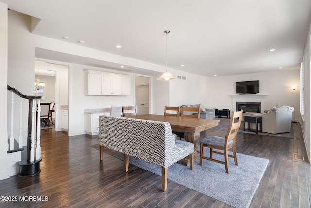 11 Potomac Ct, Freehold, NJ 07728 - dining area featuring a glass covered fireplace, dark wood-style floors, recessed lighting, and a chandelier