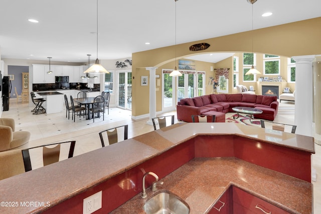 1609 Revere Ln, Wall, NJ 07753 - kitchen with open floor plan, decorative columns, a breakfast bar, black appliances, and recessed lighting
